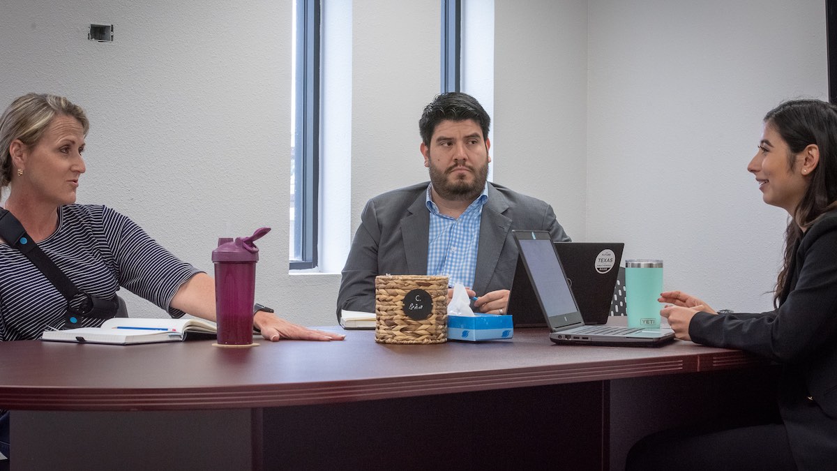 A photo of Manny, Dr. Fey and Community Partnership Specialist, Selena Madrigal, in conversation in Southwest ISD offices.
