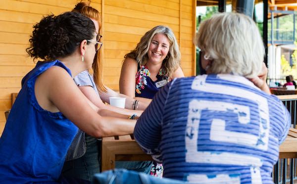 A photo of Sharon Foley, Director of Campus Programs at The Holdsworth Center, meeting with Campus Leadership Program leaders at the Campus on Lake Austin.