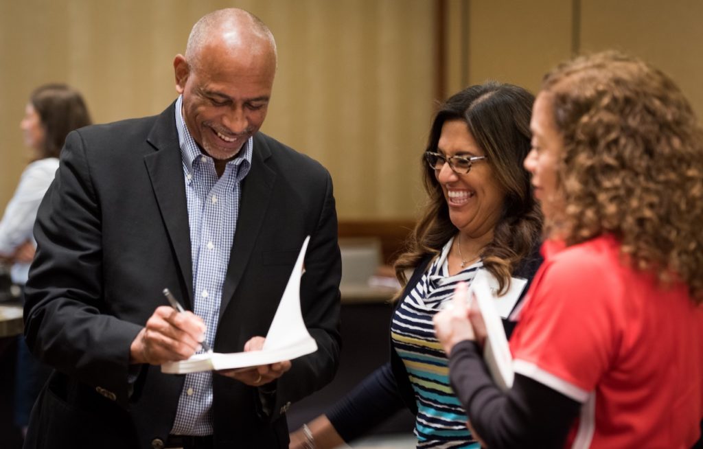 Dr. Pedro Noguera signs a book for Holdsworth district leaders after discussing equity in education.