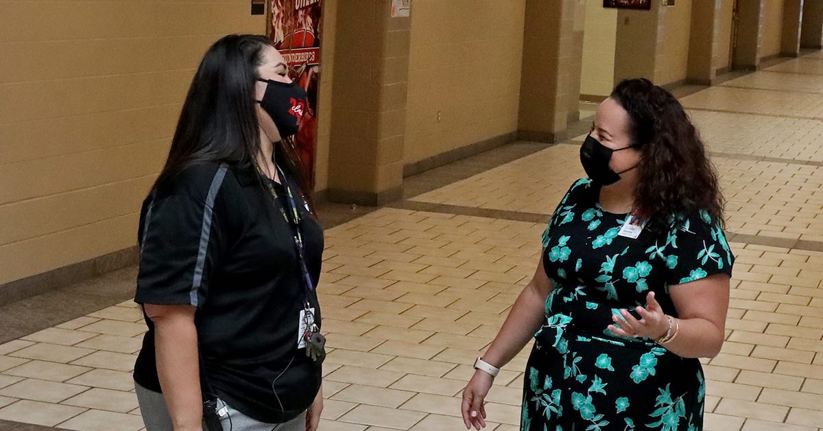 Dr. Destiny Barrera, director of leadership development, is photographed on campus talking with one of her coaches, Wagner High School Principal Priscilla Alfaro.