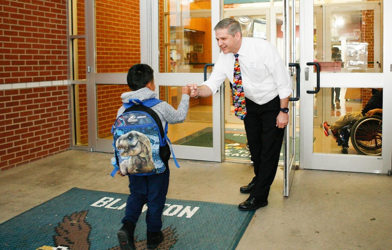 Principal Josh Leonard greets a student with a fist bump on the campus of Blanton Elementary school in Arlington ISD.