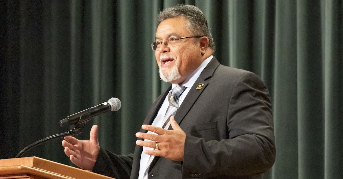 Gabe Trujillo, superintendent of Nacogdoches ISD, is photographed speaking at a podium.